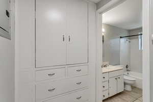 Bathroom featuring vanity, shower / washtub combination, tile patterned floors, and electric panel