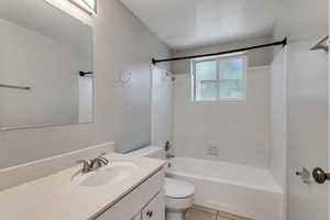 Bathroom featuring vanity, shower / bathtub combination, and tile patterned flooring