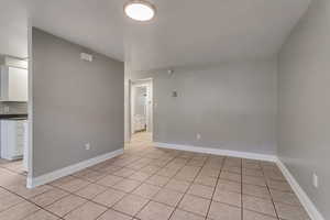 Spare room with light tile patterned flooring and baseboards
