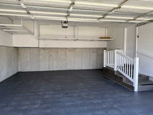 Garage featuring a garage door opener and tons of overhead storage