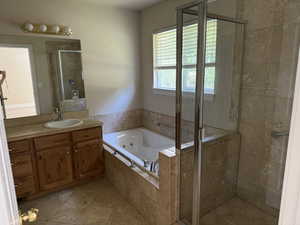 Primary bathroom with a stall shower, vanity and jetted tub