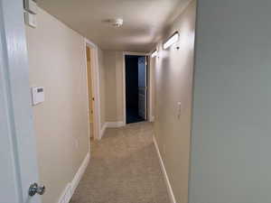 Corridor with light carpet and baseboards