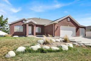 Shingled roof, driveway, and front yard