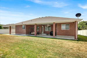 Back of house featuring  a patio area, brick siding, and a shingled roof.