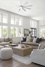 Living room featuring wood finished floors, ornamental molding, a chandelier, recessed lighting, and a ceiling fan