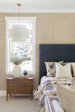 Carpeted bedroom featuring crown molding