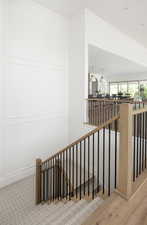Stairway with ornamental molding, a decorative wall, and recessed lighting