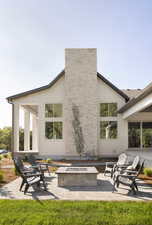 Rear view of property with a patio, a fire pit, and a chimney