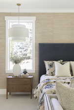 Bedroom with ornamental molding and carpet flooring