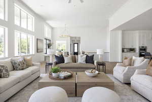 Living area featuring light wood-style flooring, ornamental molding, a chandelier, a ceiling fan, and recessed lighting