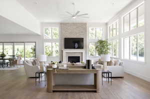 Living area featuring a ceiling fan, a brick fireplace, wood finished floors, crown molding, and recessed lighting