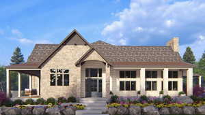 View of front of house featuring stone siding and a chimney