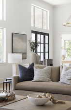 Living room featuring a chandelier, a high ceiling, crown molding, and wood finished floors