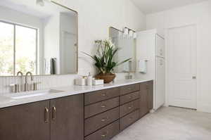 Bathroom with double vanity and wallpapered walls