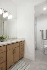 Bathroom featuring tile patterned floors, vanity, and an enclosed shower