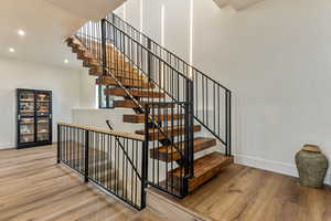 Stairs featuring wood finished floors and recessed lighting