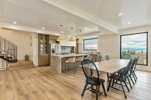 Dining room with plenty of natural light, recessed lighting, light wood-style flooring, and stairs