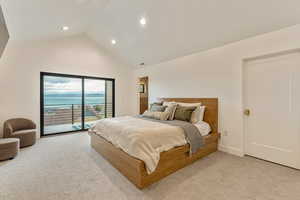 Bedroom with access to exterior, light carpet, recessed lighting, high vaulted ceiling, and a water view