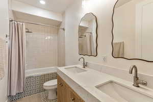 Full bathroom with tiled shower / bath, double vanity, tile patterned flooring, and recessed lighting