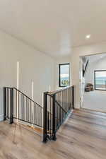 Stairway with wood finished floors and recessed lighting