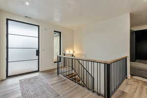 Entryway featuring light wood-style flooring, a textured ceiling, and recessed lighting