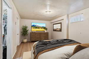 Bedroom with a textured ceiling and baseboards