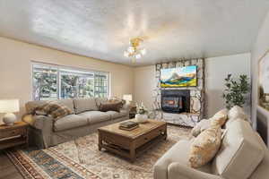 Living room with a textured ceiling, a chandelier, and wood finished floors