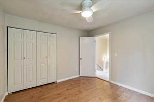 Unfurnished bedroom featuring light wood-style floors, a closet, and ceiling fan
