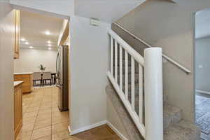 Staircase with recessed lighting and tile patterned flooring