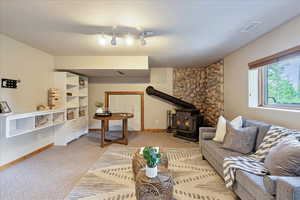Living room featuring a wood stove and light carpet