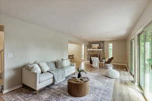 Living area with plenty of natural light, wood finished floors, and a fireplace