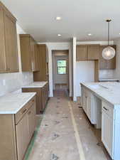 Kitchen featuring tasteful backsplash, recessed lighting, decorative light fixtures, and brown cabinetry