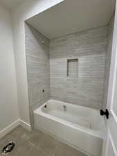 Full bath featuring tile patterned flooring and bathtub / shower combination