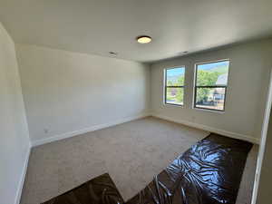 Carpeted spare room with baseboards