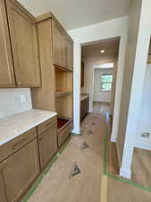 Kitchen featuring decorative backsplash and light stone countertops