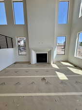 Unfurnished living room with a high ceiling and healthy amount of natural light