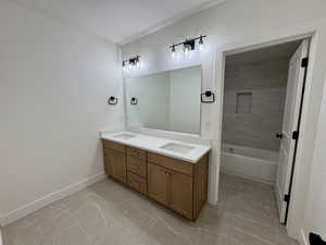 Full bathroom featuring double vanity, tile patterned floors, and tub / shower combination