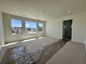 Carpeted empty room featuring baseboards and recessed lighting