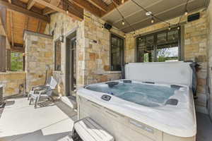 Covered porch with a hot tub