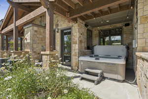 View of patio with a hot tub