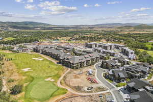 Aerial view of property and surrounding area with mountains and a golf club