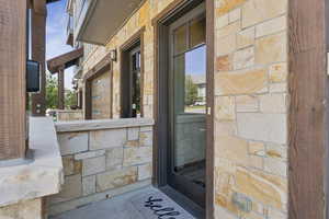 Doorway to property featuring stone siding