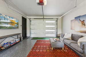 Garage featuring a garage door opener and baseboards