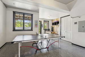 Rec room featuring electric panel and speckle patterned floor