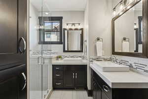 Full bath featuring vanity, a stall shower, decorative backsplash, and tile patterned floors