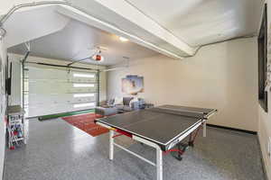Rec room with a garage and speckled floor