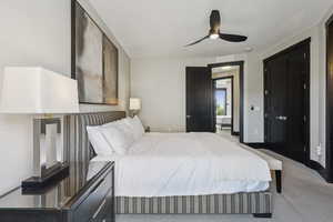 Carpeted bedroom with a ceiling fan