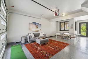 Recreation room with a garage and speckled floor