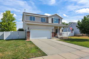 Traditional home featuring a gate, covered porch, concrete driveway, an attached garage, and brick siding