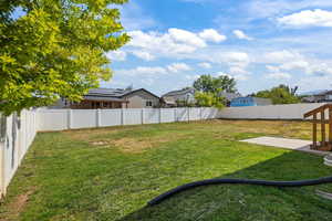 Fenced backyard featuring a patio and a residential view